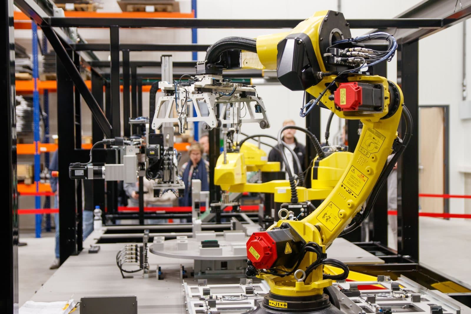 Yellow industrial robot arm working in an automated assembly cell